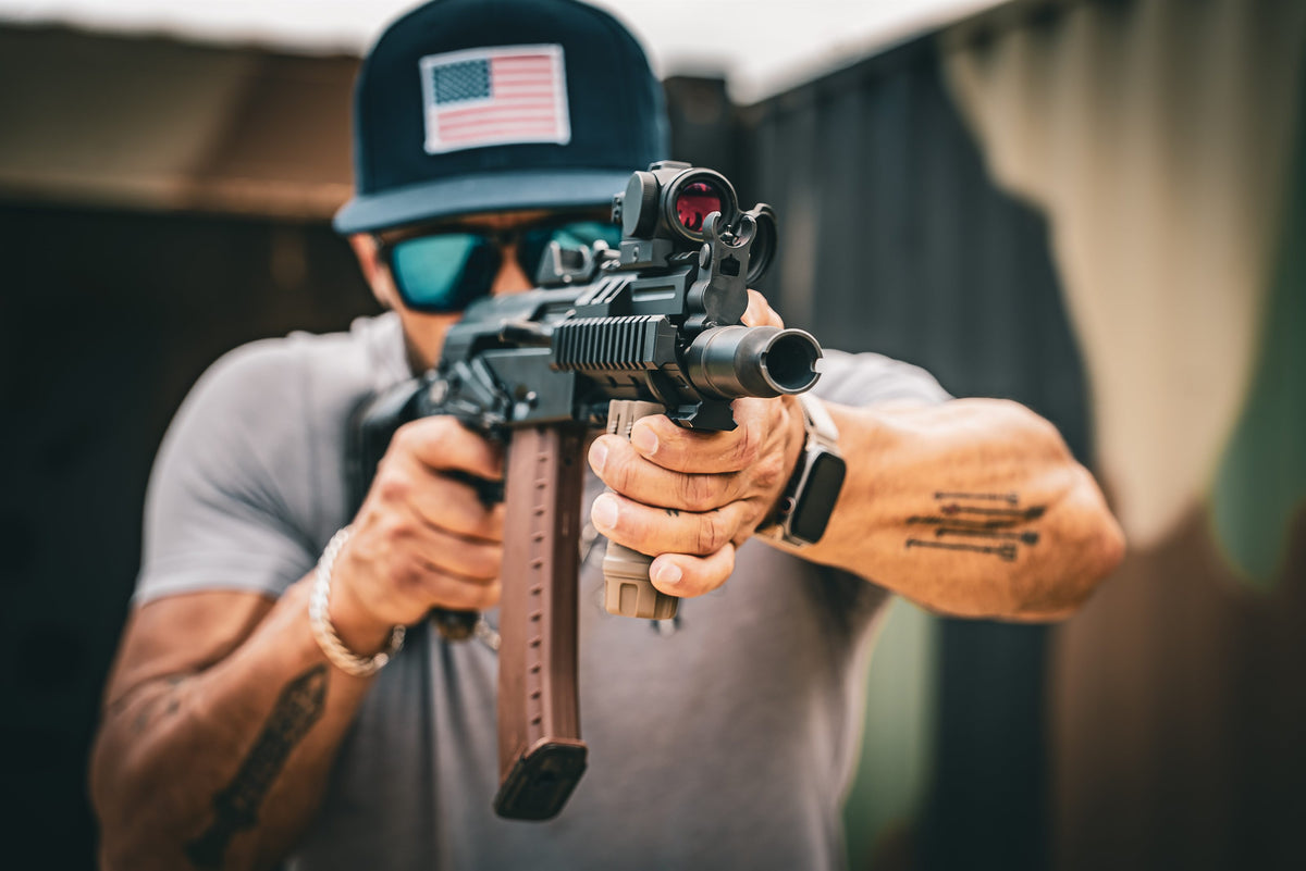 A shooter on the line with a rifle shouldered, shallow depth of field.