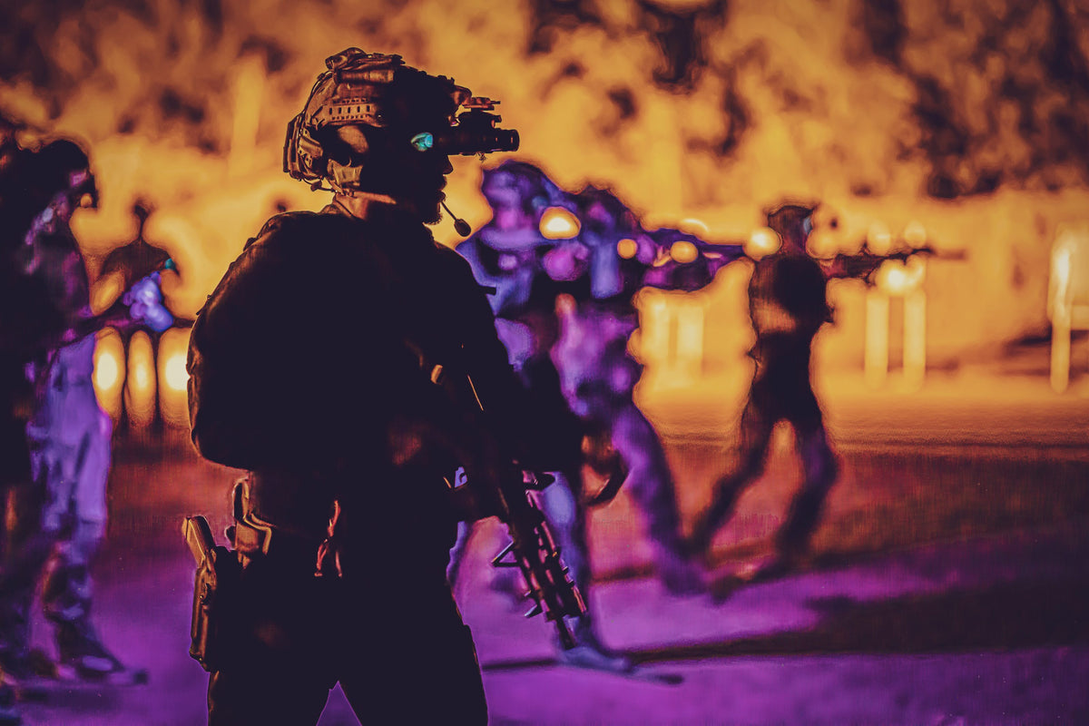 Students with night vision silhouetted on a lowlight firing line.