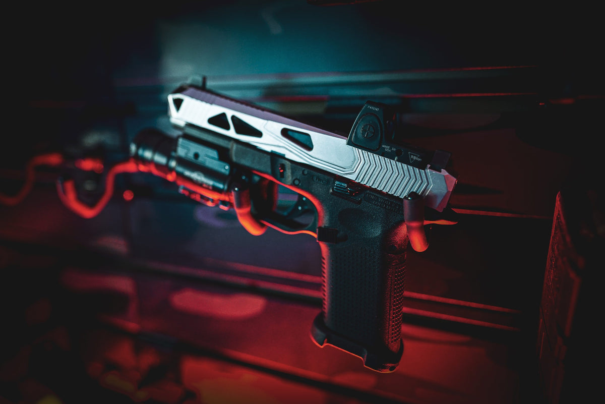 A competition pistol lit in red, laid flat against a dark background.
